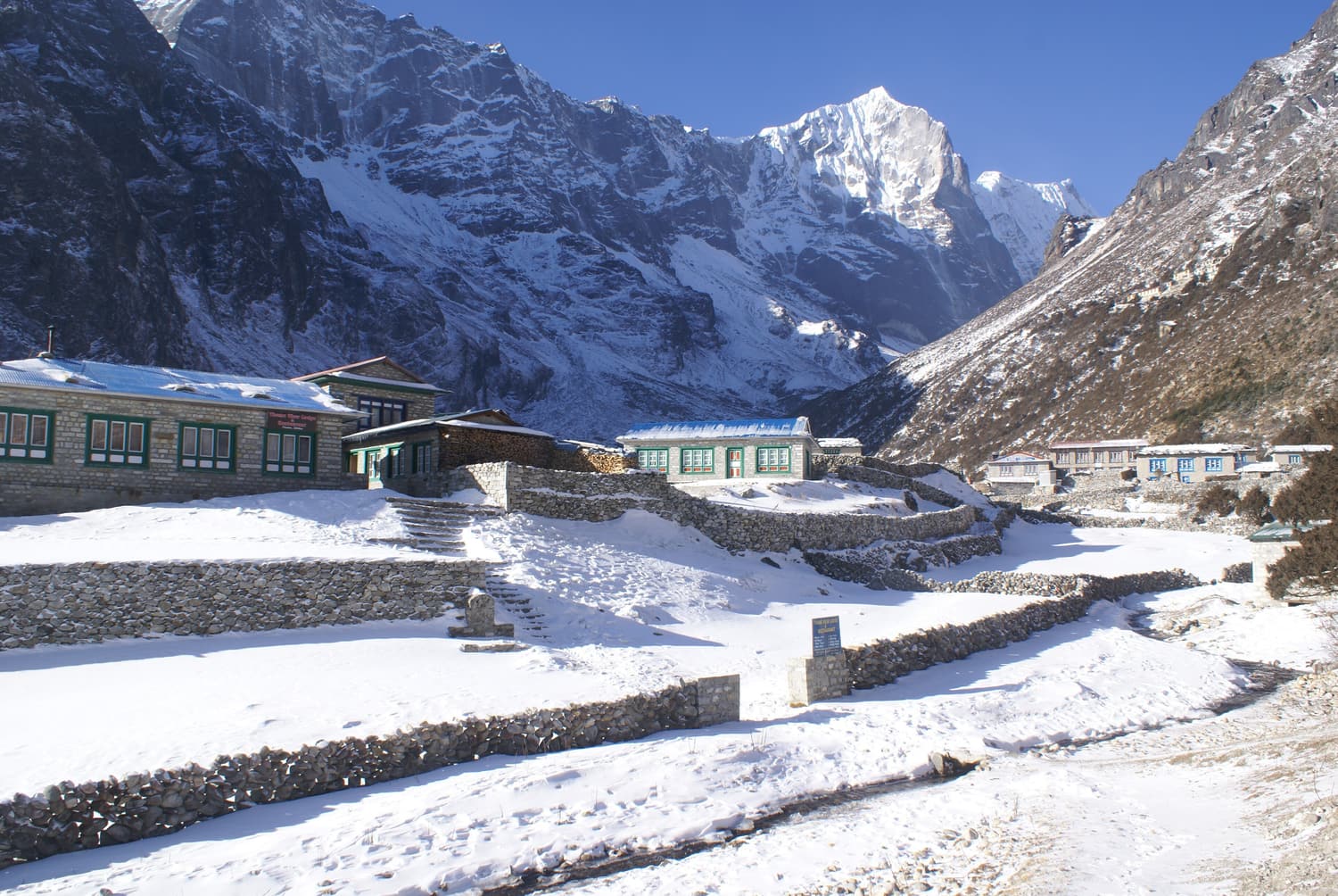 Lodges von Thame unter frischem Schnee, dahinter hohe Gipfel
