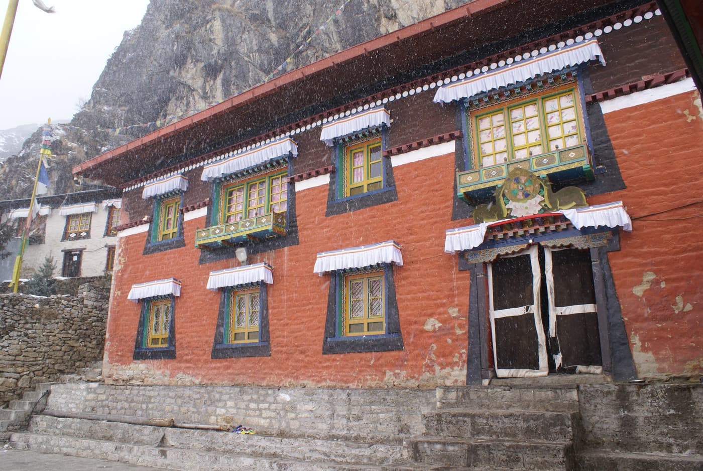 Die rote Fassade des Klosters von Thame unter einer Felswand